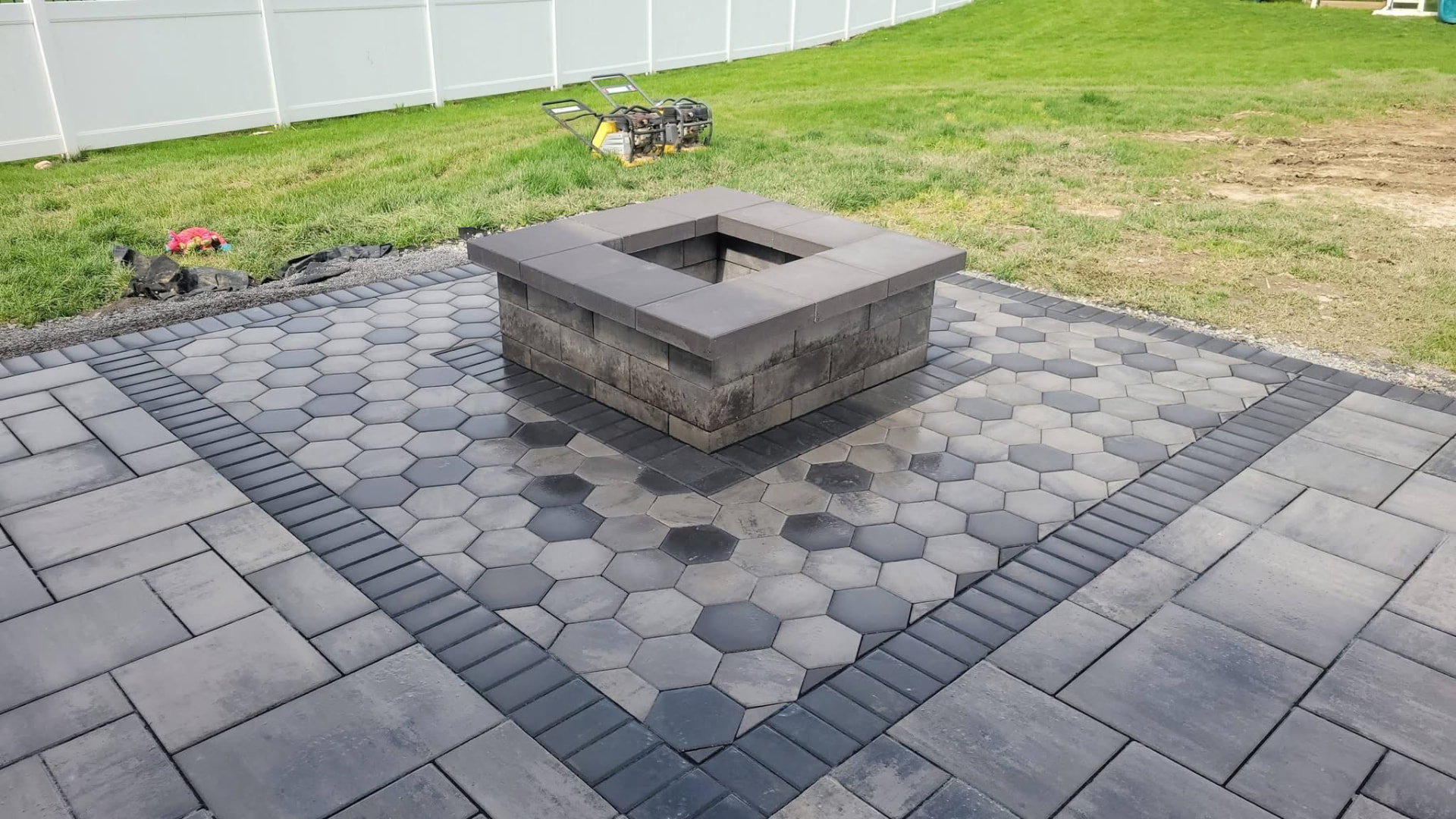 A patio with a hexagonal inlay and fire pit